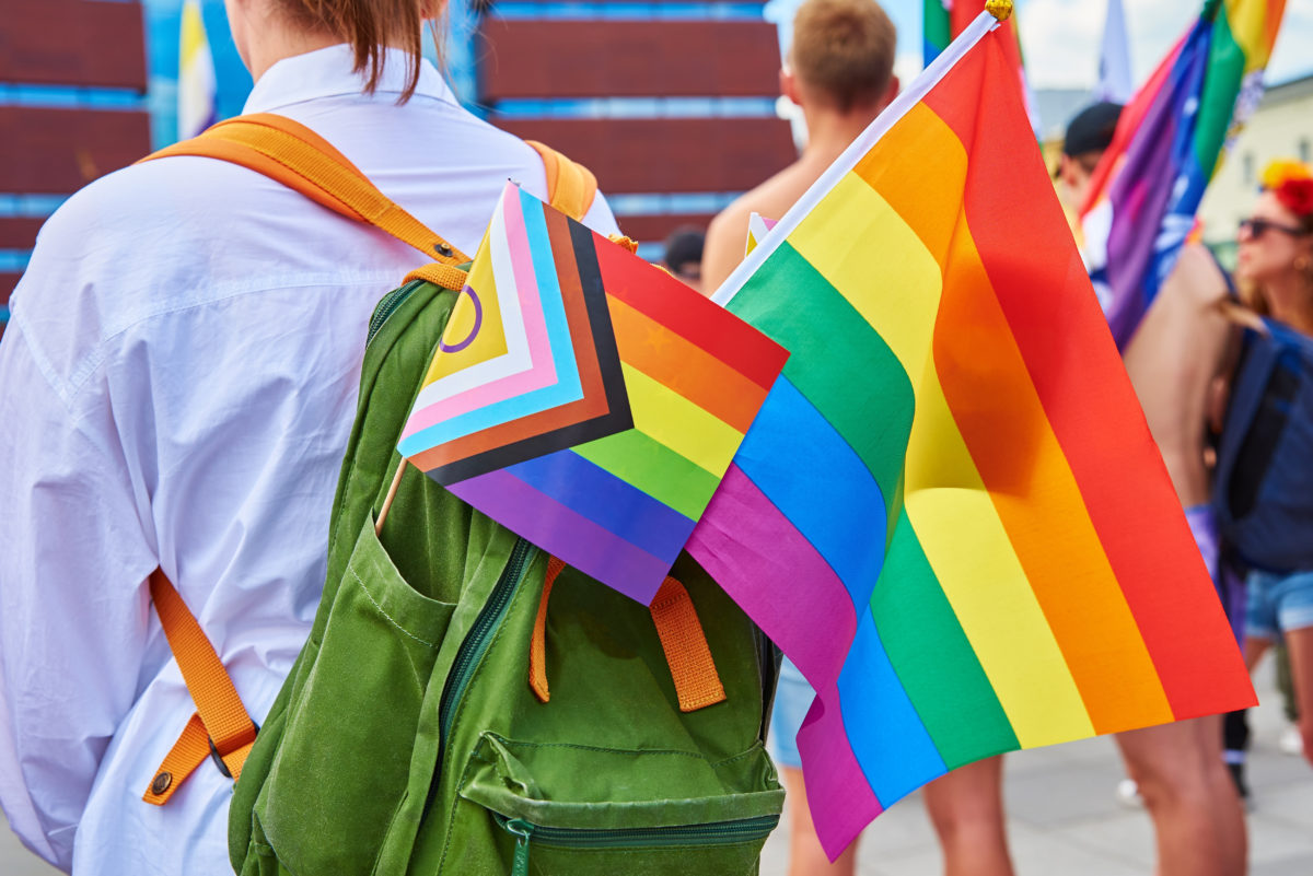 People with LGBTQ rainbow flags on pride parade. Tolerance, diversity and gender identity concept